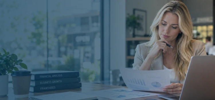 Blonde franchise investor reviewing financial reports and cash flow projections before buying a franchise.
