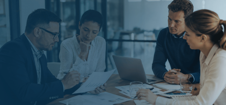 Franchise experts reviewing performance audit reports and financial data in a professional office.