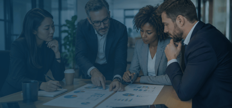 Business valuation experts reviewing financial charts and reports during a professional advisory meeting in a modern office.