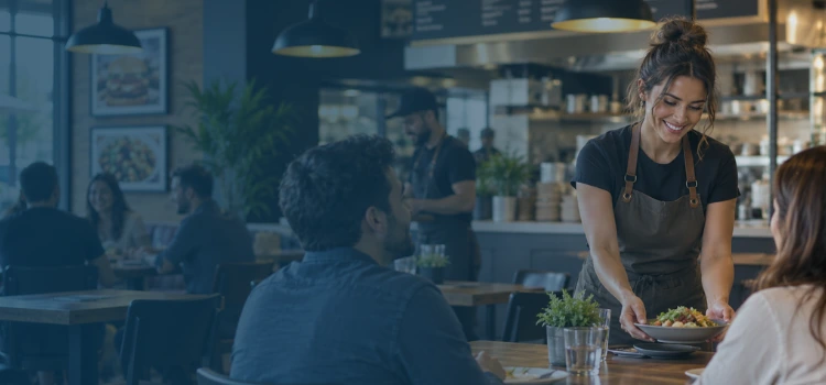 Franchise restaurant employee serving customers in a busy dining area, representing day-to-day business operations and financial management.
